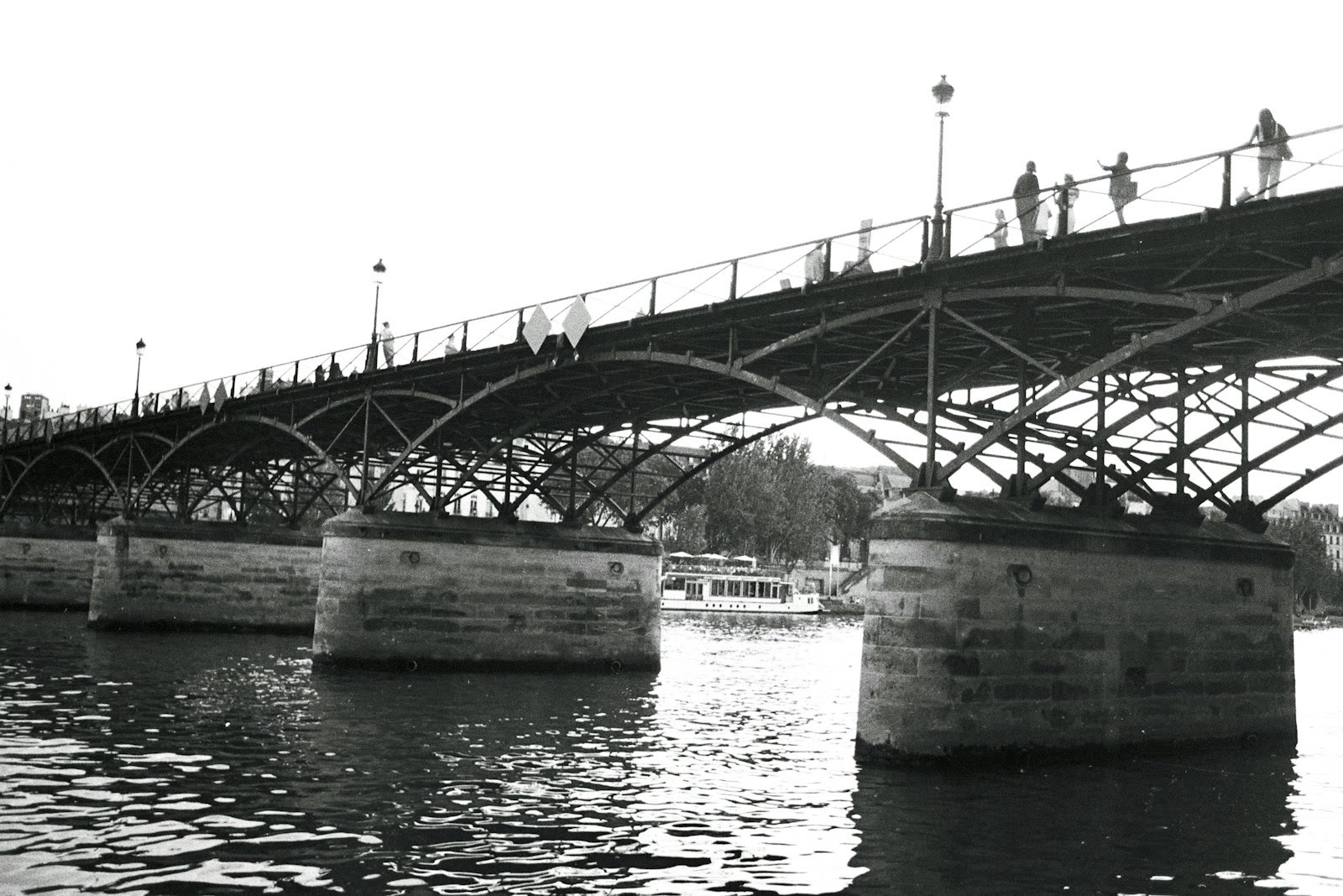 a black and white photo of a bridge over water